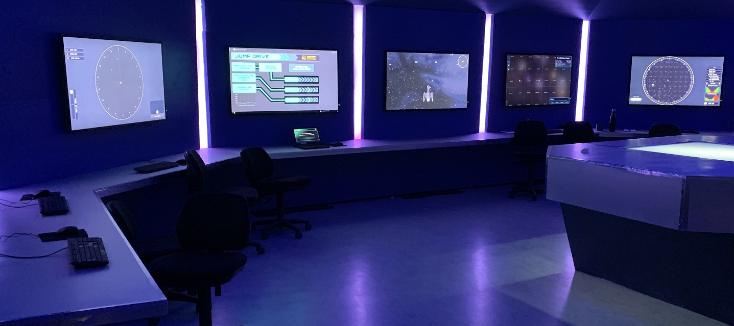 Photo of the scenography. Bridge of a space ship in blue lighting.